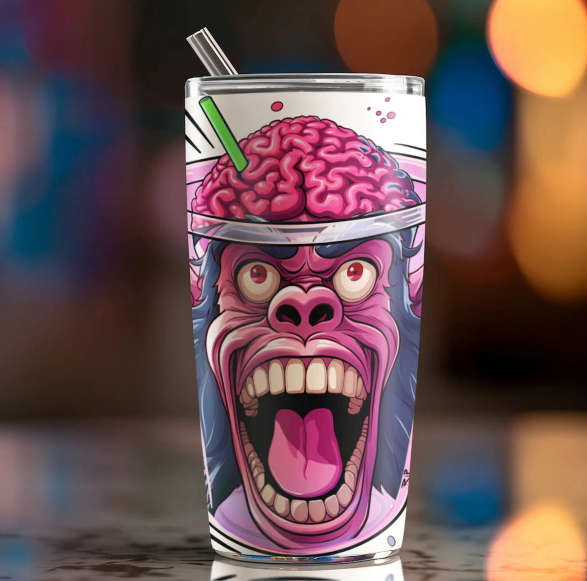 “Monkey Brain tumbler with a screaming pink monkey and exposed brain graphic, clear lid and straw against blurred lights.” A insulated tumbler with a straw, featuring a cartoon graphic of a screaming pink gmonkey with a brain on its head, set against a blurred colorful background. brain freeze