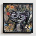 A framed abstract painting of a stylized skunk character with large eyes and a wide grin, shown against a textured multicolor background. The artwork is housed in a black frame and hangs on a light wall.