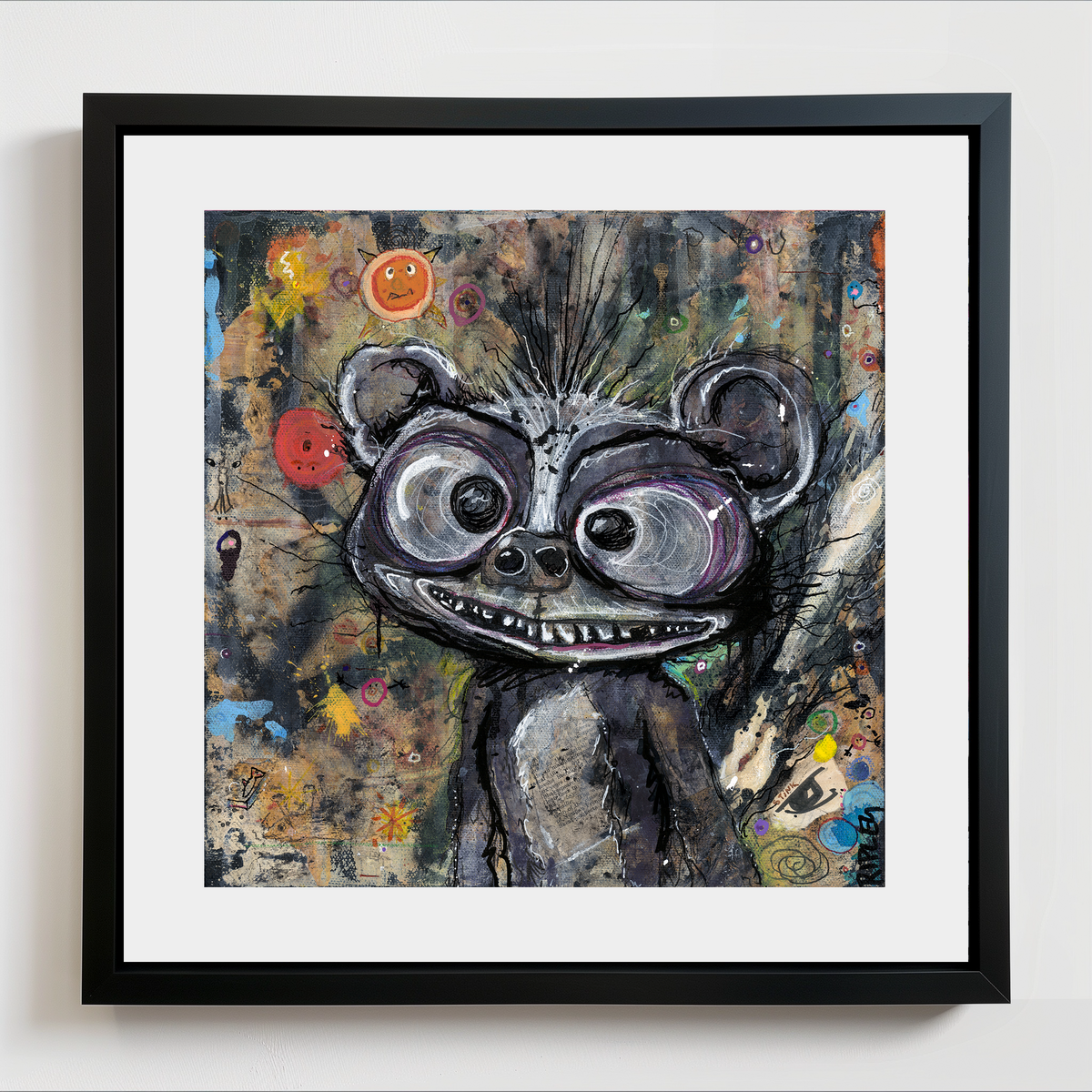 A framed art print featuring a whimsical, textured painting of a cartoon-like skunk with large eyes and a toothy grin, set against a dark, abstract background. The artwork is presented in a black frame with a white mat board, mounted on a light gray wall.