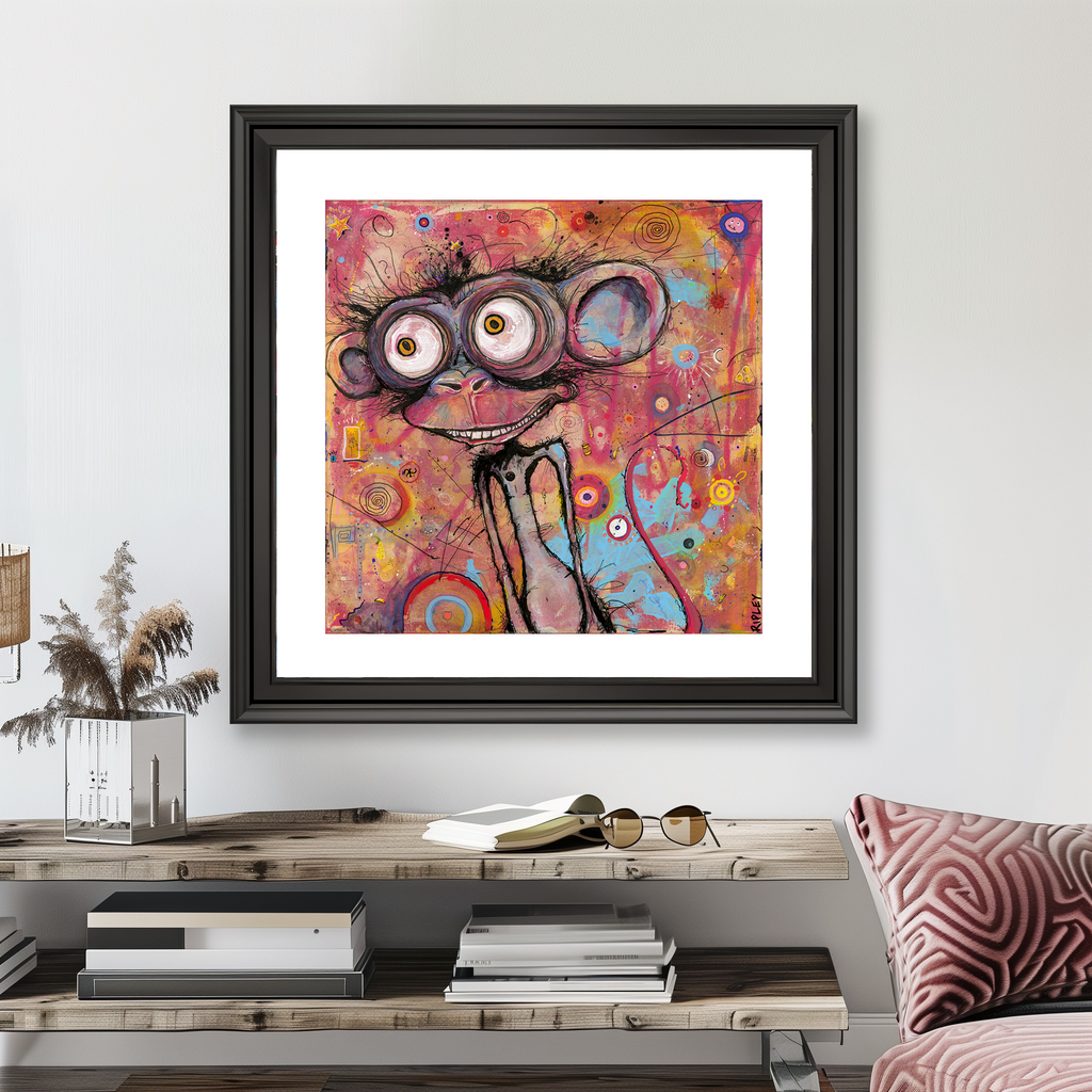 A framed abstract art print featuring a whimsical cartoon face with large eyes and glasses, hanging on a light gray wall above a wooden console table in a styled living room setting.